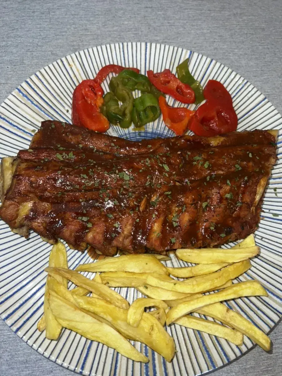 Costillas a la barbacoa con patatas fritas y pimientos asados en Relaax Colombiano