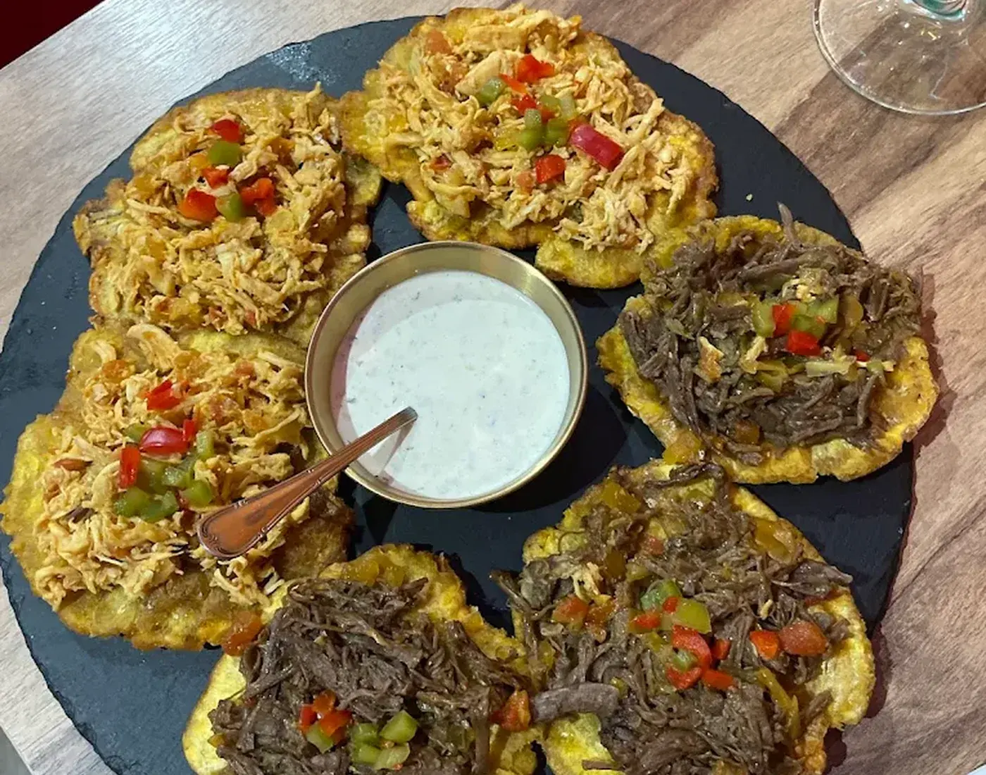 Patacones de pollo y carne servidos al centro de la mesa en Relaax Colombiano